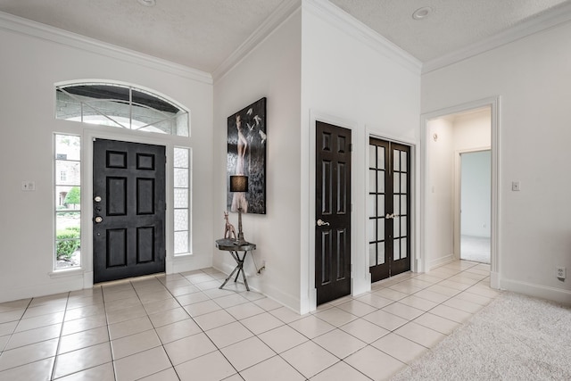 tiled foyer featuring crown molding and a textured ceiling