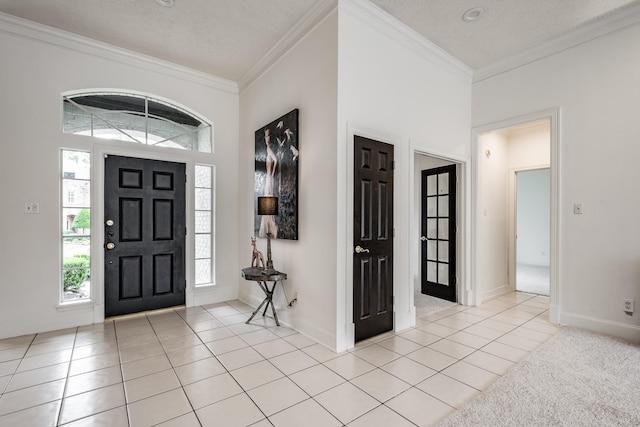 foyer with crown molding, light tile patterned floors, and a textured ceiling