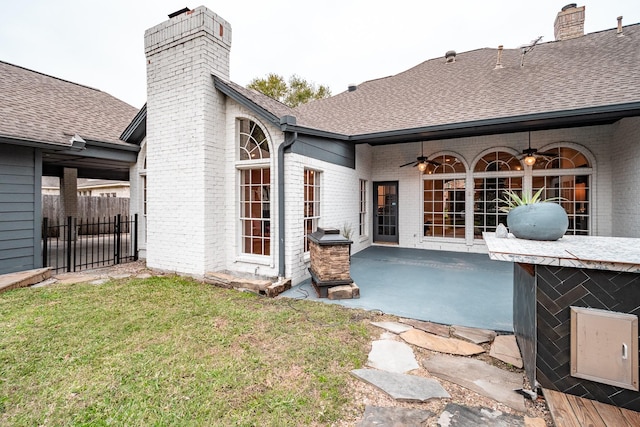 back of house featuring ceiling fan, a yard, and a patio