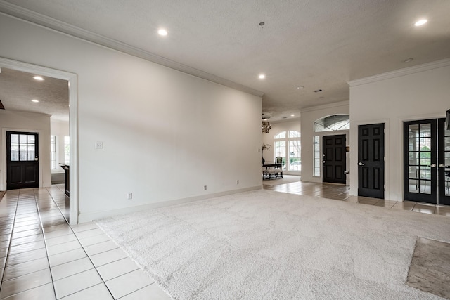 unfurnished living room featuring a textured ceiling, crown molding, and light carpet