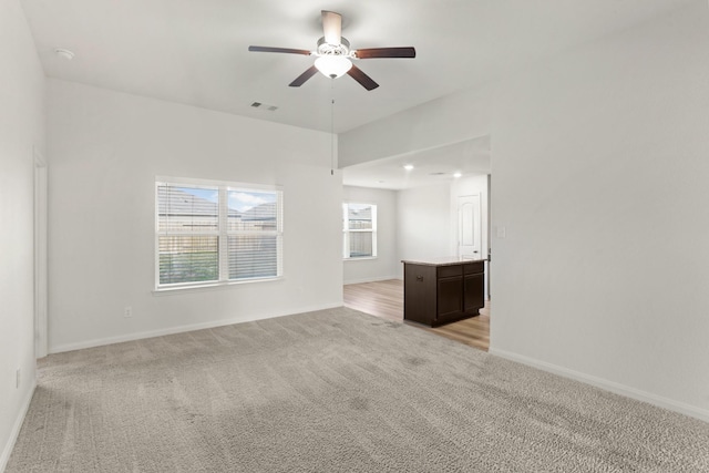 empty room with ceiling fan and light colored carpet