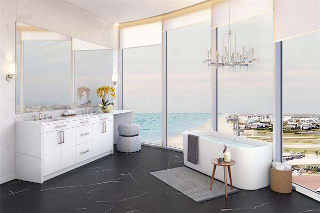 full bath with double vanity, a water view, a sink, a freestanding bath, and a notable chandelier