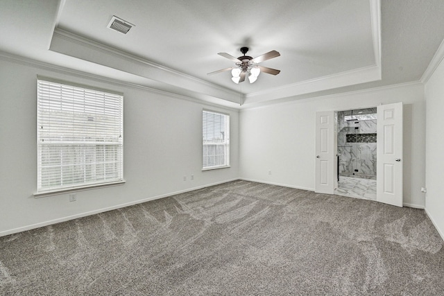 carpeted spare room featuring a tray ceiling, a wealth of natural light, and crown molding