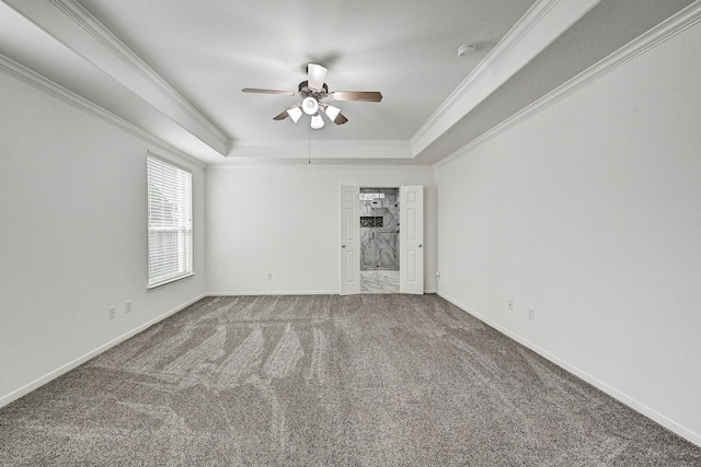 unfurnished room with carpet flooring, ceiling fan, ornamental molding, and a tray ceiling