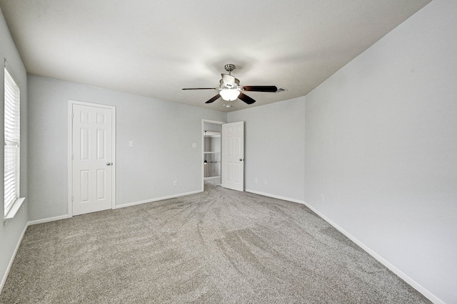 unfurnished bedroom featuring multiple windows, ceiling fan, and carpet floors