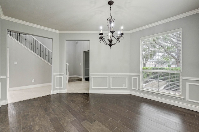 spare room with a chandelier, crown molding, and dark wood-type flooring