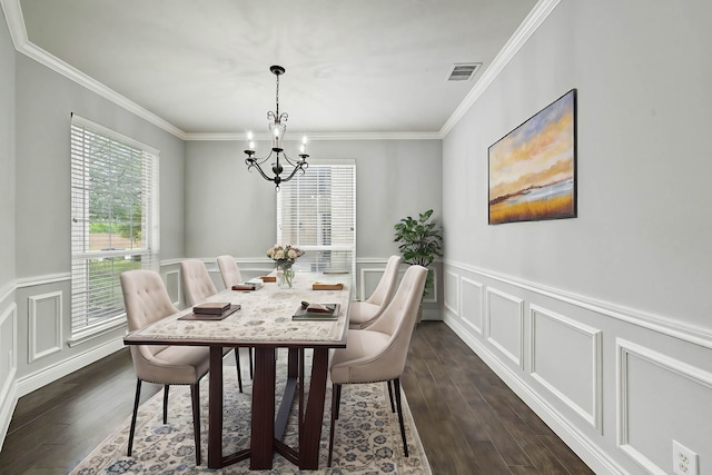 dining space featuring dark hardwood / wood-style floors, an inviting chandelier, and crown molding