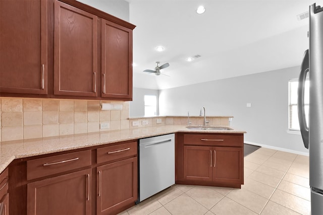 kitchen with light stone countertops, appliances with stainless steel finishes, decorative backsplash, ceiling fan, and sink