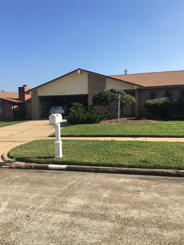 single story home featuring a garage and a front lawn