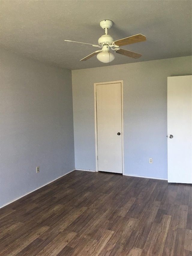 unfurnished room with a textured ceiling and dark wood-type flooring