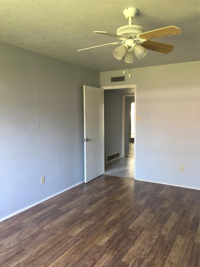 unfurnished room with ceiling fan, dark hardwood / wood-style flooring, and a textured ceiling