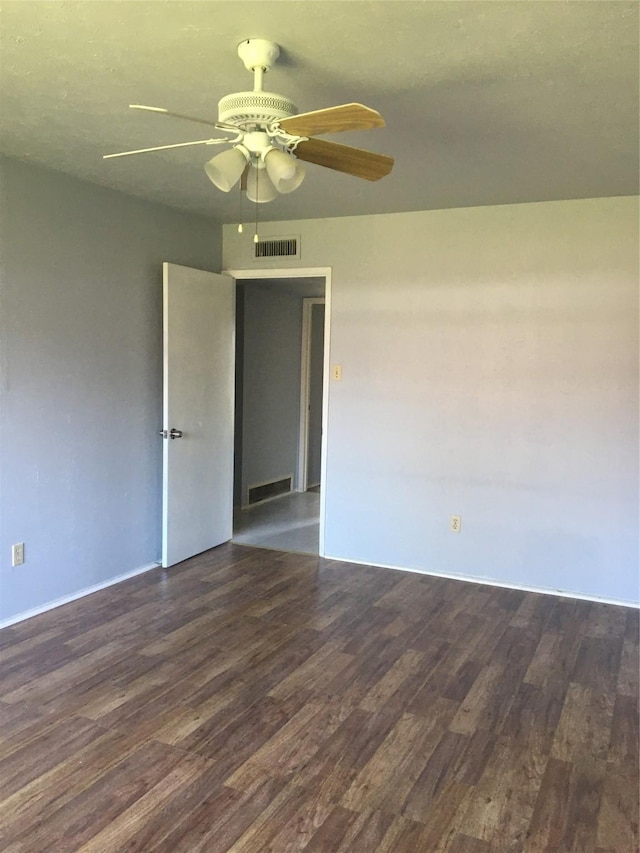 empty room featuring ceiling fan and dark hardwood / wood-style flooring