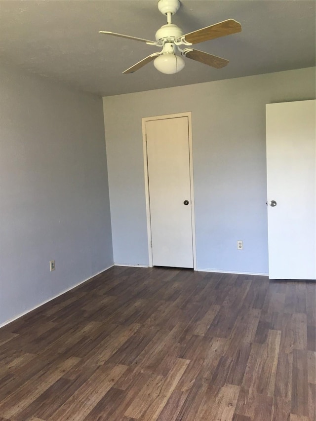 empty room featuring ceiling fan and dark wood-type flooring