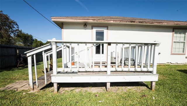 rear view of property featuring a wooden deck and a yard