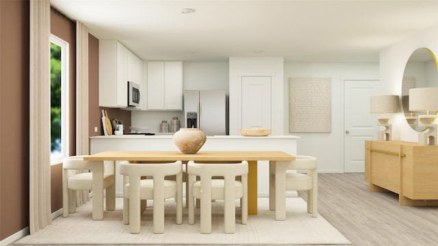 kitchen featuring white refrigerator with ice dispenser, light wood-type flooring, and white cabinetry