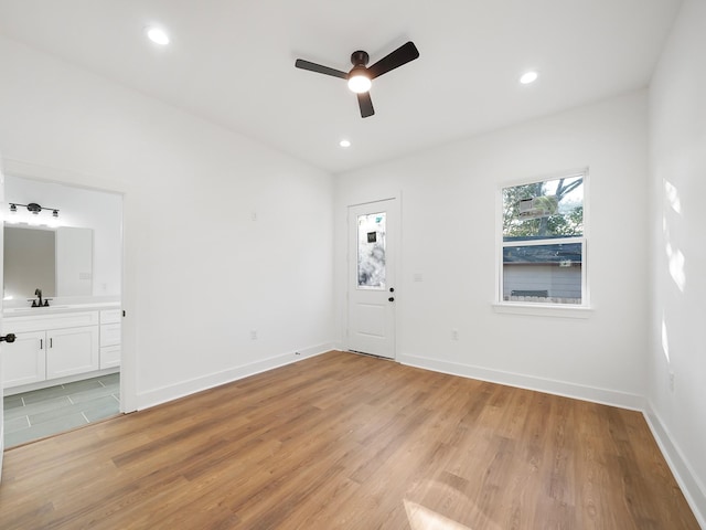 spare room with ceiling fan, sink, and light hardwood / wood-style floors