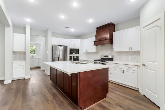 303 Kalmer St, Pasadena, TX 77502 - kitchen with stainless steel appliances, backsplash, light countertops, dark wood-style floors, and a kitchen island with sink