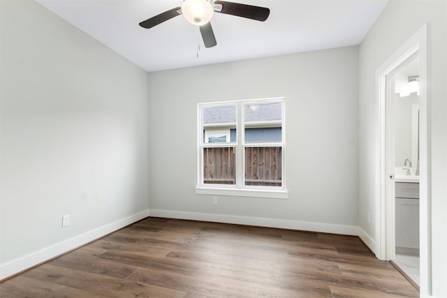 unfurnished room with ceiling fan, sink, and dark wood-type flooring