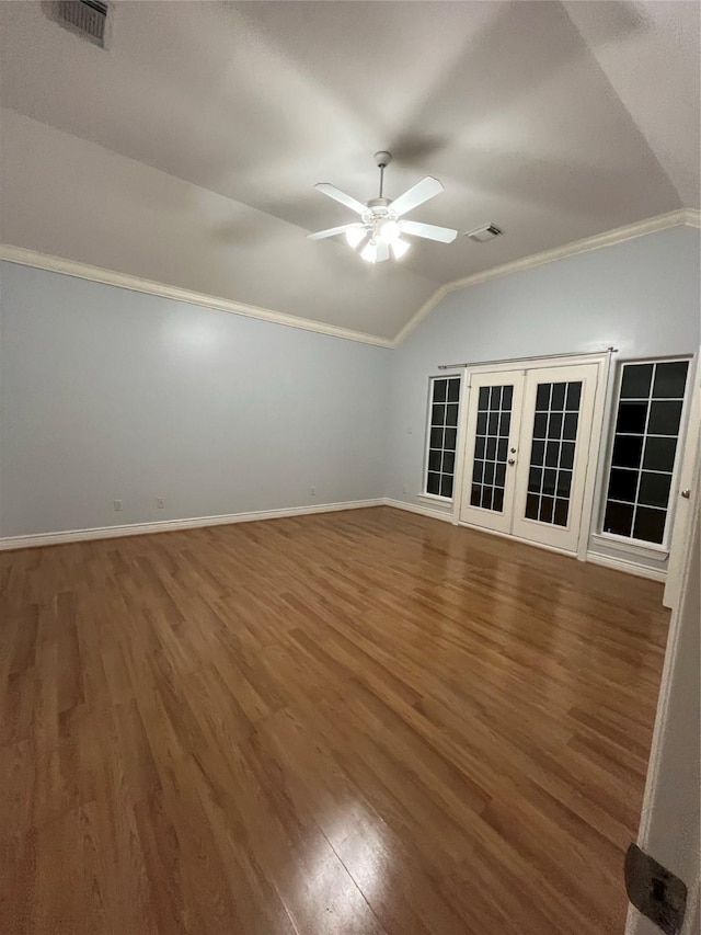 spare room with crown molding, ceiling fan, dark hardwood / wood-style floors, vaulted ceiling, and french doors