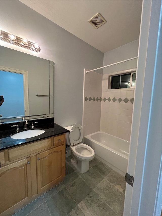 bathroom with vanity,  shower combination, toilet, and visible vents