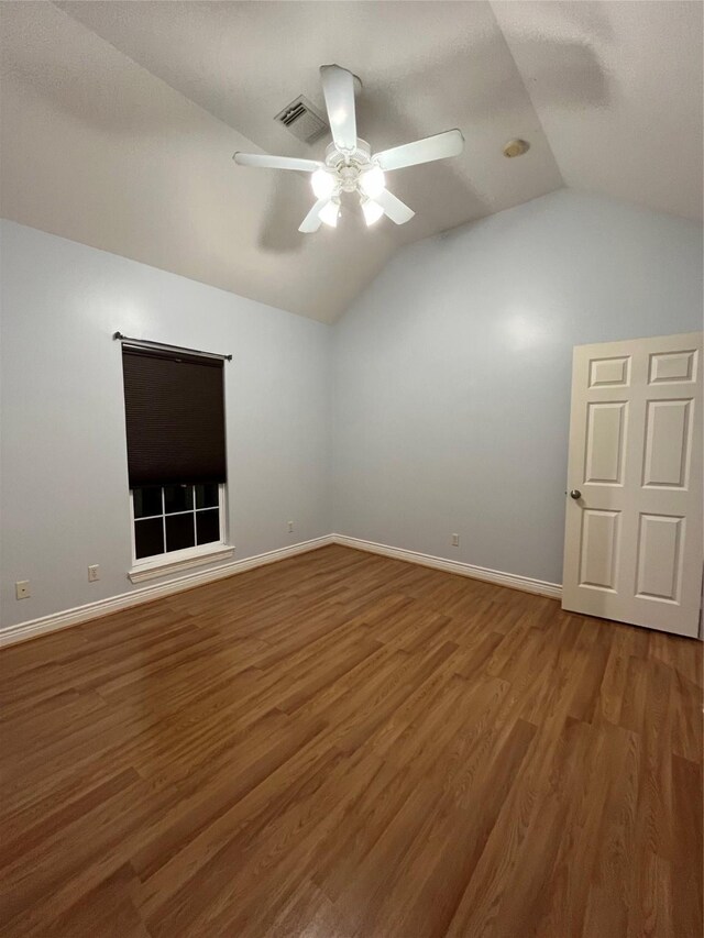 spare room with ceiling fan, vaulted ceiling, and hardwood / wood-style floors