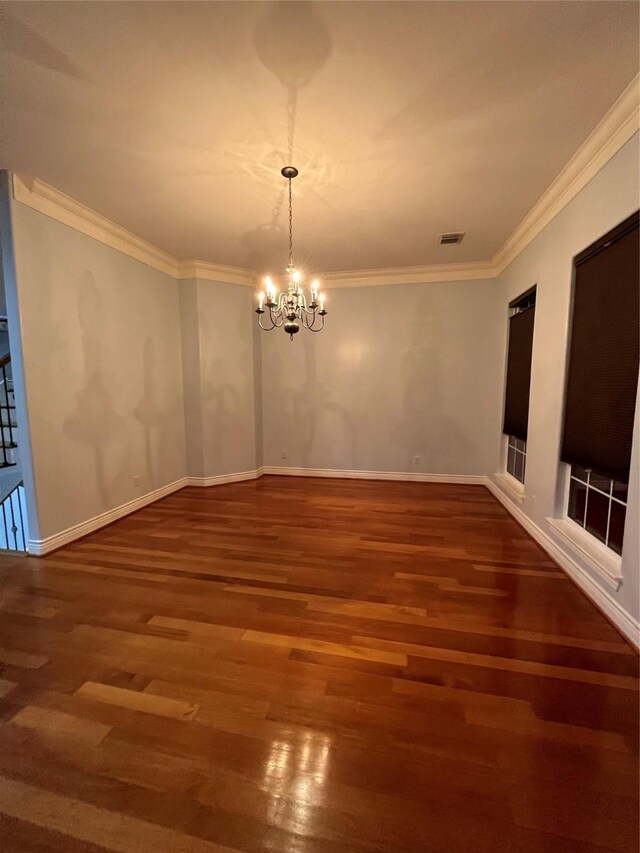 unfurnished dining area featuring crown molding, dark hardwood / wood-style floors, and a notable chandelier