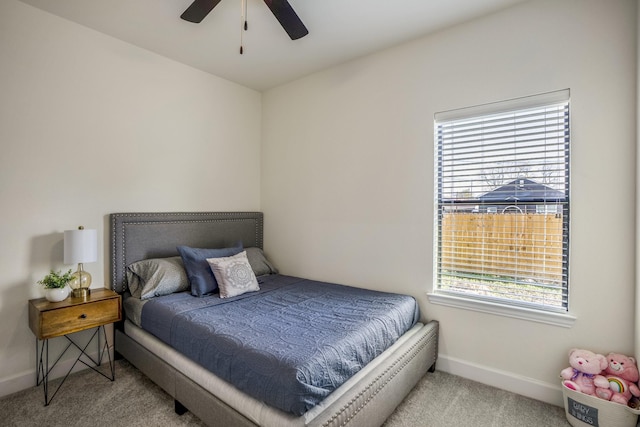 bedroom with multiple windows, ceiling fan, and light carpet