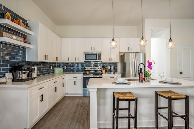 kitchen with white cabinetry, hanging light fixtures, and stainless steel appliances