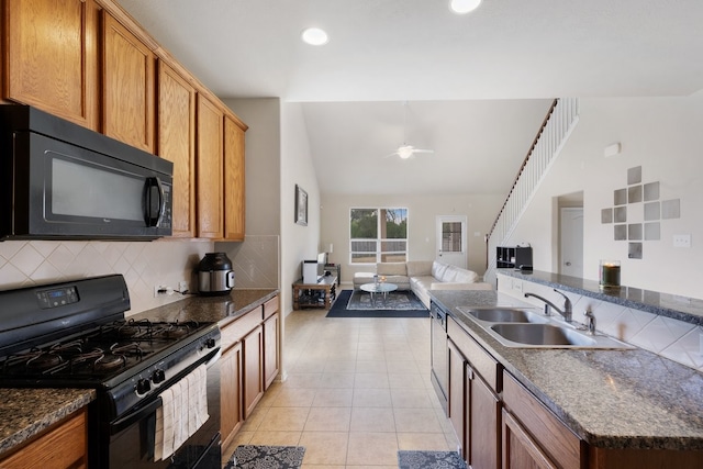 kitchen featuring tasteful backsplash, vaulted ceiling, sink, black appliances, and light tile patterned floors