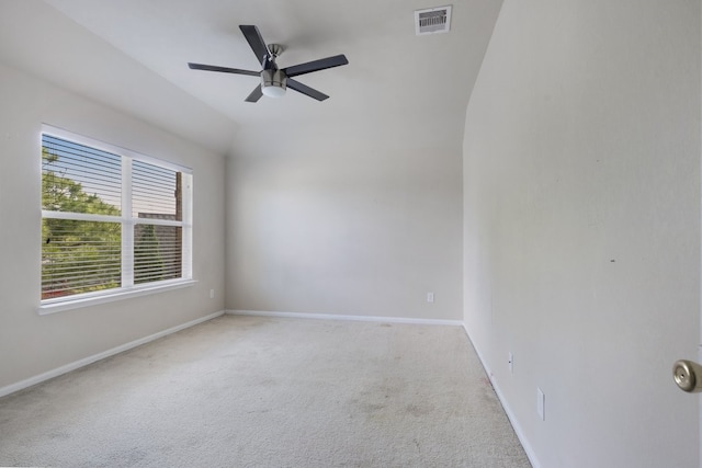 carpeted spare room with ceiling fan and vaulted ceiling