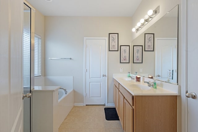 bathroom with a washtub, vanity, and tile patterned flooring