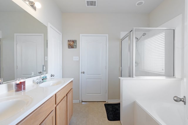 bathroom featuring plus walk in shower, vanity, and tile patterned flooring