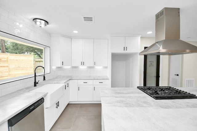 kitchen with tasteful backsplash, island exhaust hood, white cabinetry, and stainless steel dishwasher