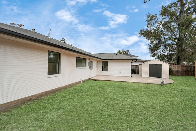 rear view of property featuring a patio, a storage unit, and a lawn