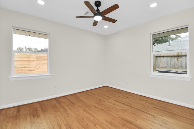 spare room with ceiling fan, plenty of natural light, and light hardwood / wood-style flooring