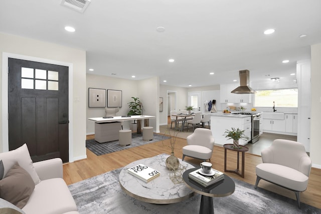 living room with light hardwood / wood-style flooring and sink