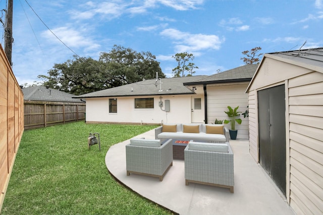 rear view of property featuring a lawn, an outdoor living space with a fire pit, and a patio