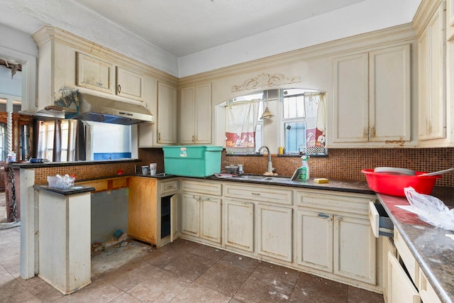 kitchen with cream cabinetry, backsplash, and sink