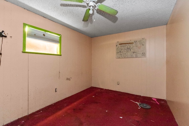 carpeted empty room featuring ceiling fan and a textured ceiling