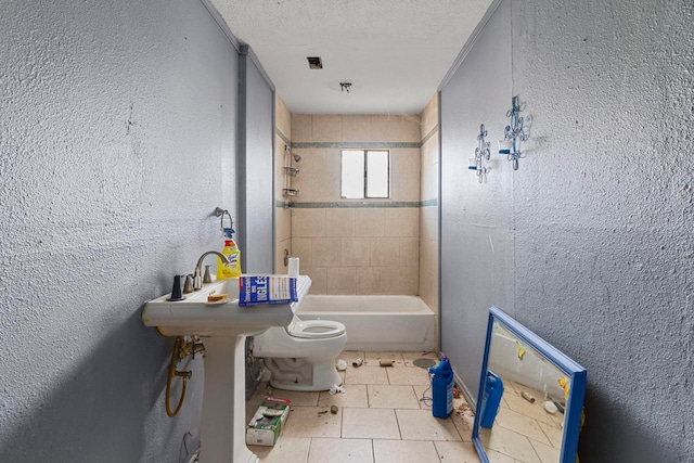 full bathroom featuring sink, tiled shower / bath, a textured ceiling, and toilet