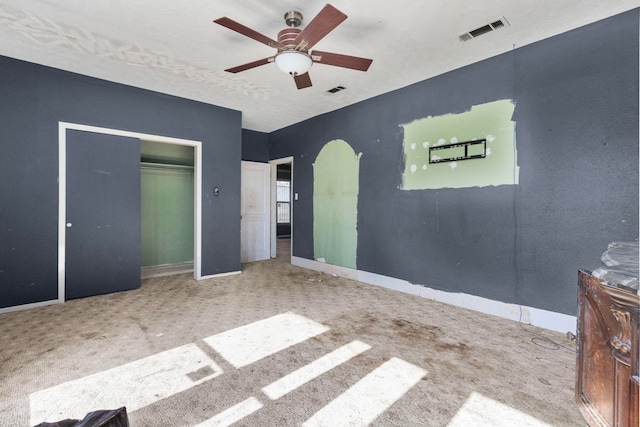 unfurnished bedroom featuring ceiling fan, a closet, and carpet