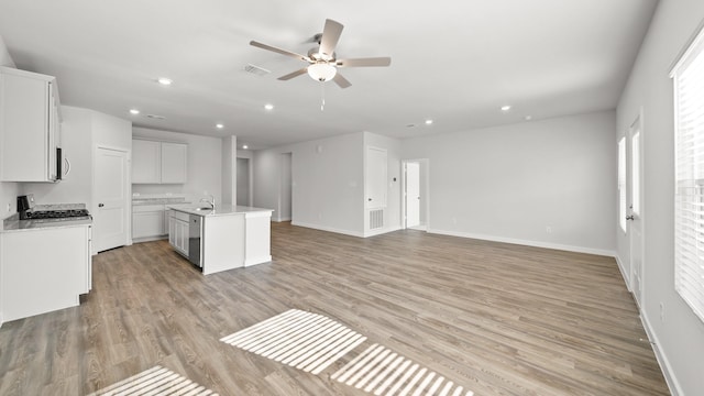 kitchen featuring light hardwood / wood-style floors, white cabinetry, stainless steel appliances, and an island with sink