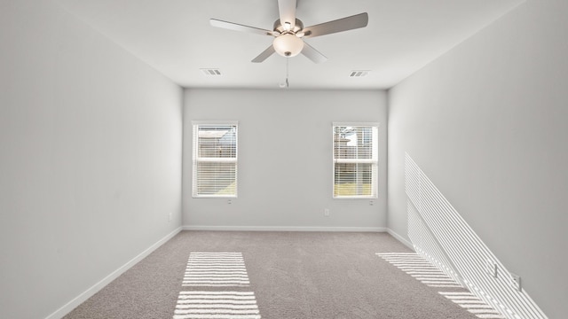 unfurnished room with ceiling fan, light colored carpet, and plenty of natural light