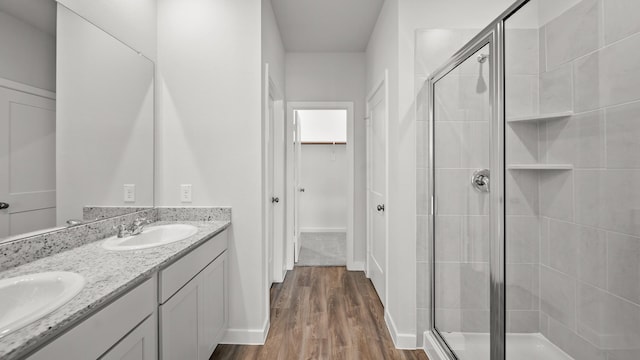 bathroom featuring wood-type flooring, walk in shower, and vanity