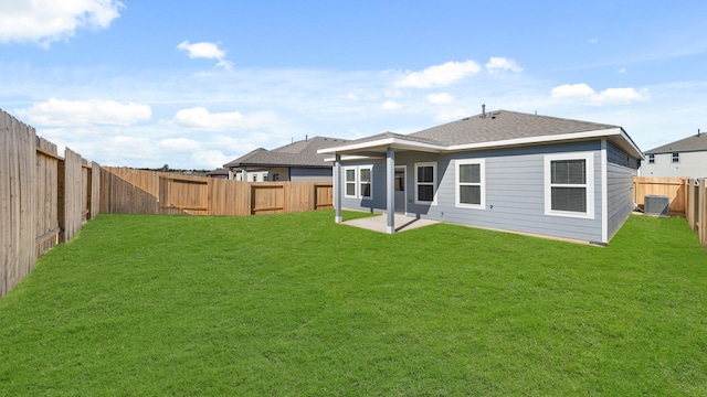 rear view of property with central air condition unit, a lawn, and a patio