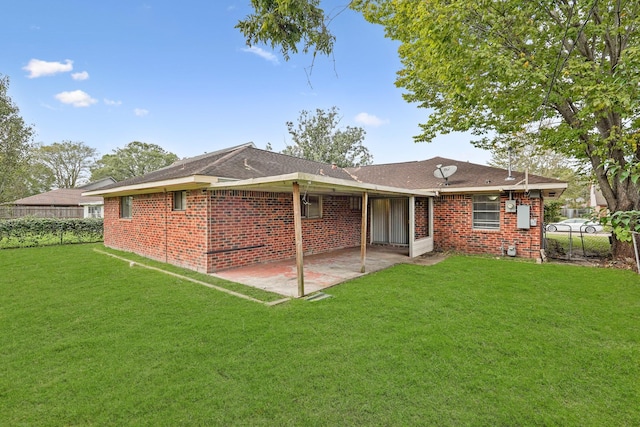 back of property with a lawn and a patio area