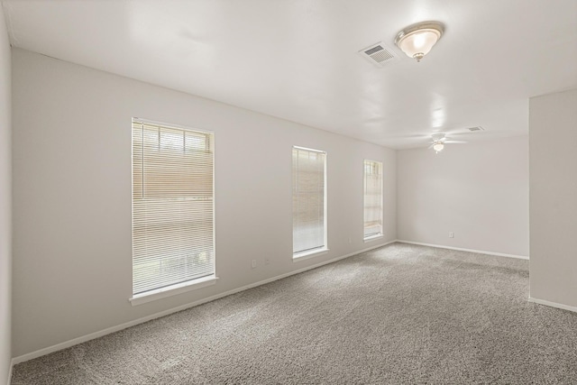 spare room with carpet flooring, ceiling fan, and a wealth of natural light