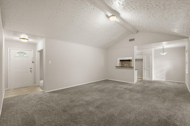 unfurnished living room featuring carpet flooring, a textured ceiling, and lofted ceiling with beams