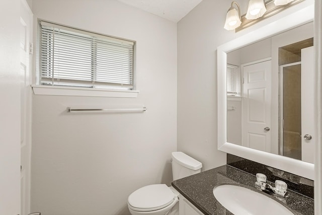 bathroom featuring vanity, toilet, and walk in shower