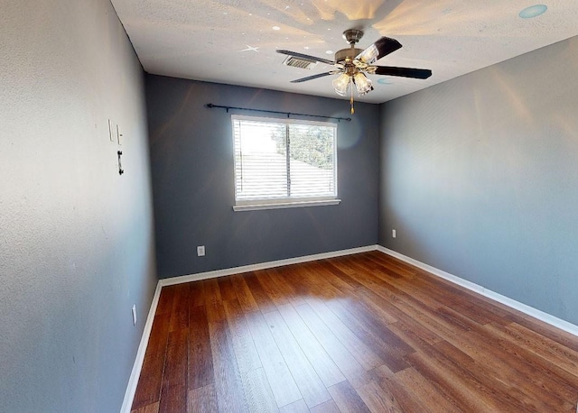 spare room featuring ceiling fan and dark hardwood / wood-style flooring